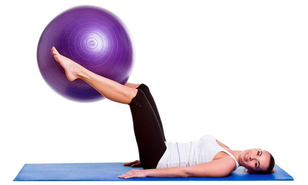 Ejercicio con pelota de pilates elevación pierna o tijera
