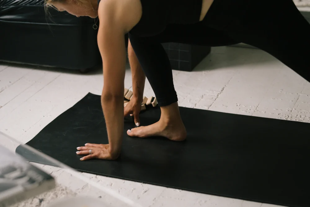 Mujer practicando el split frontal sobre una esterilla