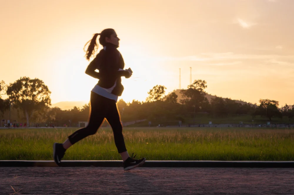 Mujer adulta corriendo a ritmo suave por un parque por la mañana