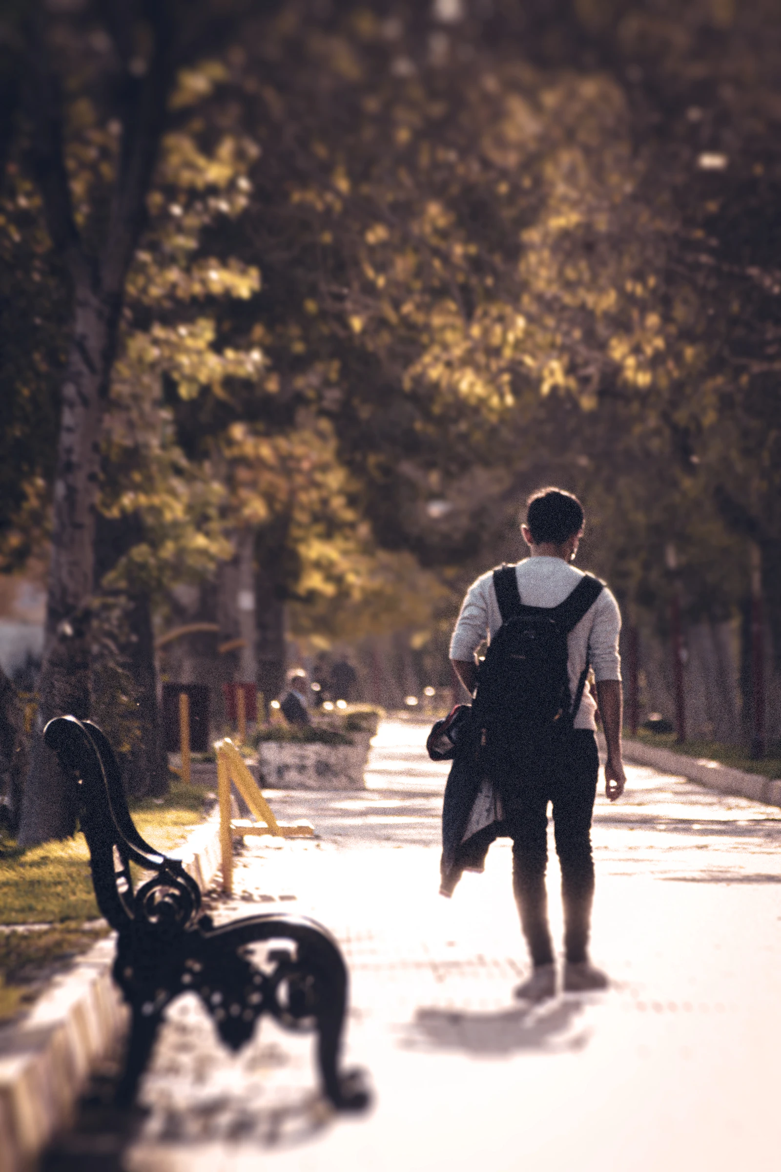 Hombre caminando a paso rápido por un parque urbano